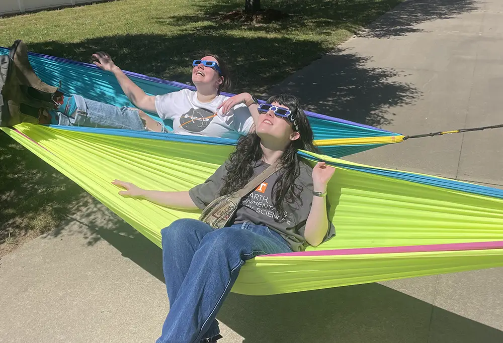 Students sitting in hammocks watching the Eclipse