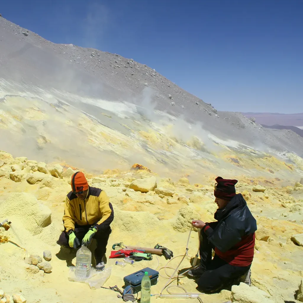 Researchers kneeling and gathering samples in the field