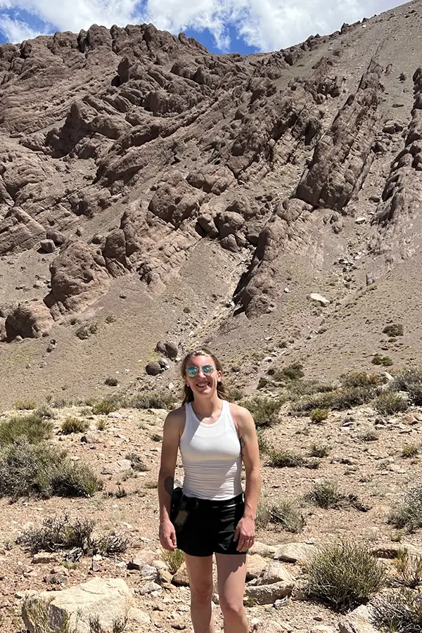 A photo of Chelsea Mackaman-Lofland in front of rocky cliffslides