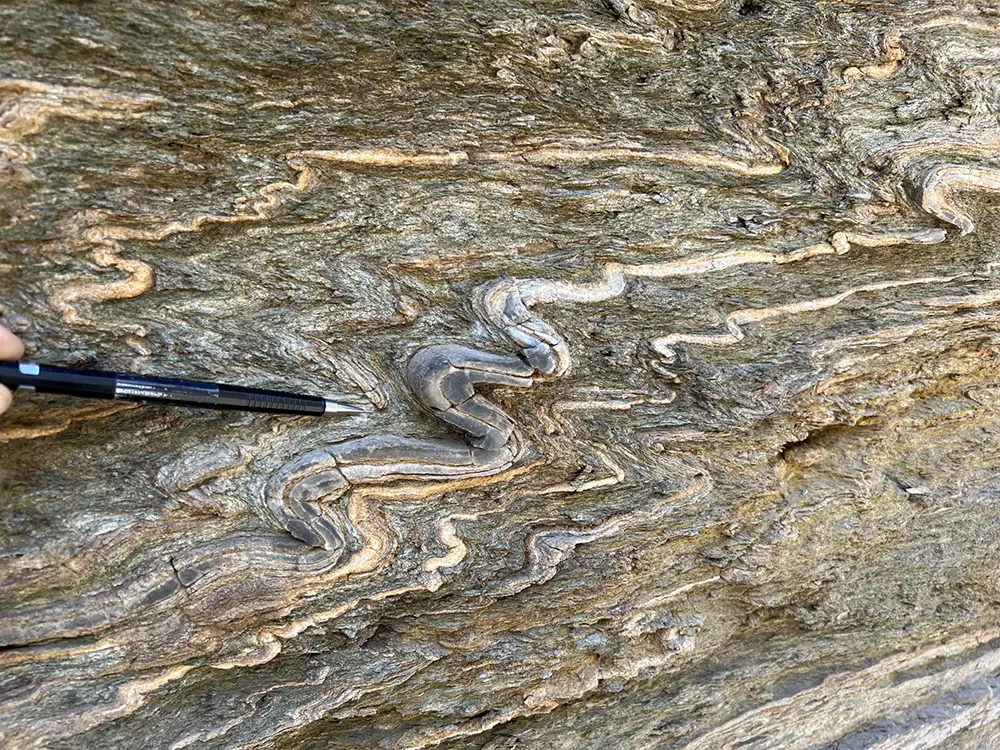 A pen pointing at a feature of a rock formation